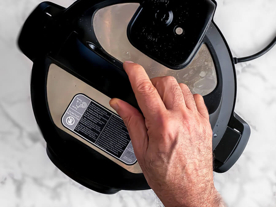 hand closing lid of instant pot
